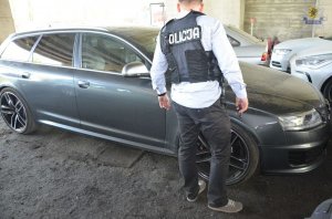 Policjant na tle odzyskanego audi