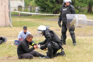 Policjanci udzielają pomocy rannym kibicom