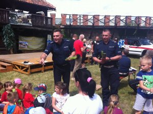 policjanci wręczający odblaski dzieciom