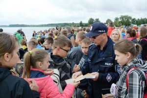 policjant rozdający ulotki dzieciom