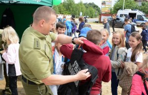 dzieci przymierzają kamizelkę Straży Grancznej