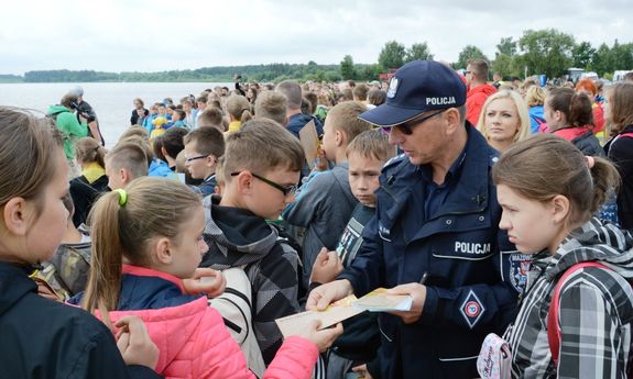 policjant rozdający ulotki dzieciom