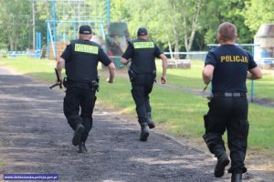 biegnący policjanci w czarnych mundurach typu moro