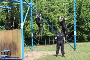 policjanci wspinają się na siatkę z łańcuchów