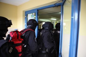 uzbrojeni i zamaskowani policjanci wchodzą do szkoły