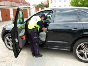 Policjantka przeszukuje odzyskane audi