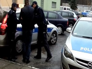 Zatrzymany prowadzony przez policjantów do radiowozu