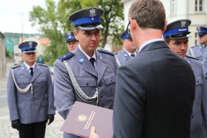 policjant odbiera wyróżnienie od przedstawiciela Wojewody Kujawsko Pomorskiego