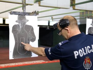 Policjant sprawdza przestrzeliny w tarczy