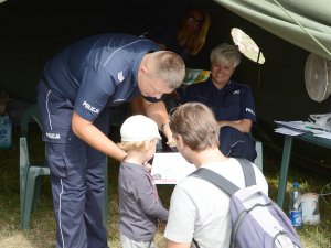 Policjant rozmawiający z dzieckiem i jego opiekunem