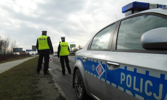 Policjanci z drogówki i policyjny radiowóz