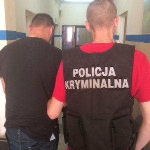 Policjant prowadzi zatrzymanego