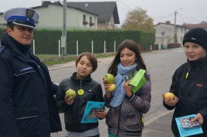 Policjantka z dziećmi biorącymi udział w akcji