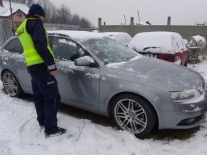 Policjant przy odzyskanym samochodzie