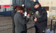 Policjant przestrzega starszą osobę przed oszustami