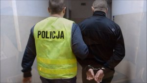 Policjant prowadzi zatrzymanego