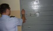 Policjant zamyka drzwi policyjnej celi - zdjęcie poglądowe