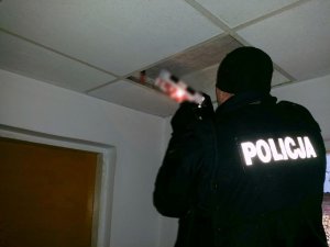 Policjant wyciąga ze skrytki papierosy bez akcyzy