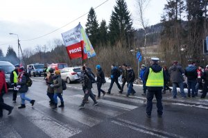 Piesi na przejściu i policjant kierujący ruchem