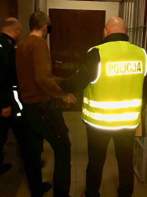 Policjanci prowadzą zatrzymanego