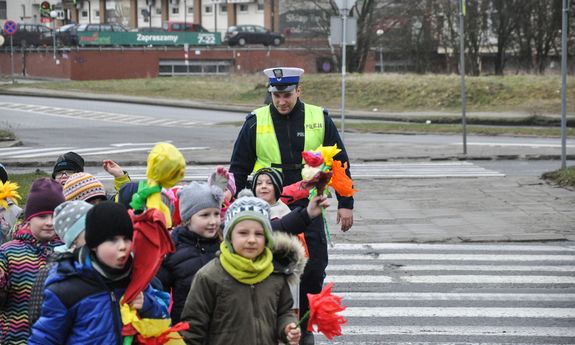 policjant przeprowadza dzieci przez przejście