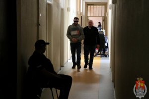 Jeden z zatrzymanych prowadzony przez policjanta