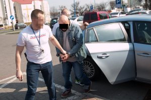 policjanci prowadzą jednego z zatrzymanych