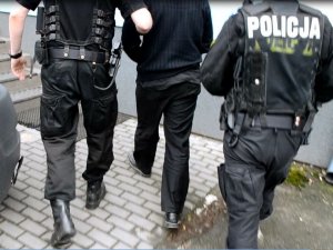 policjanci prowadzą zatrzymanego