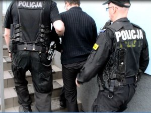 policjanci prowadzą zatrzymanego