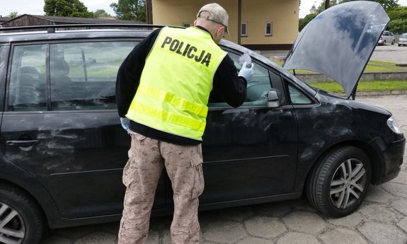 Policjant wykonuje oględziny samochodu