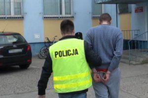 policjant prowadzi zatrzymanego