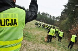 policjanci i strażacy przeszukujący teren