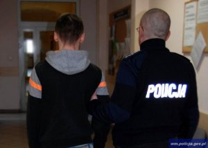 policjant prowadzi zatrzymanego