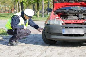 policjant kontrolujący stan techniczny pojazdu