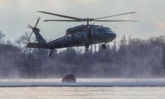 Śmigłowiec nabiera wody do zbiornika bambi bucket.