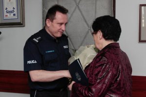 Pani Stefania otrzymuje kwiaty od Policjanta