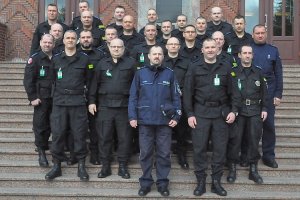 Wspólne zdjęcie uczestników na schodach głównego budynku dydaktycznego Szkoły Policji w Słupsku.
