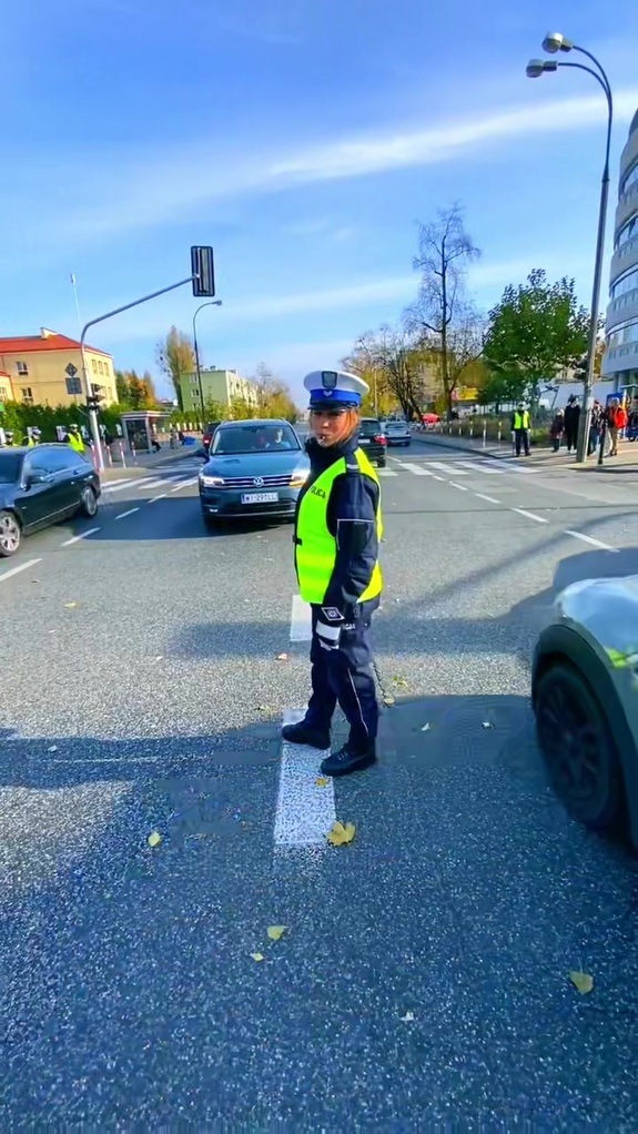 Policjant kieruje ruchem na ulicy.