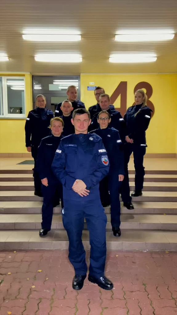 Policjanci i policjantki stoją na schodach ustawieni w klin.