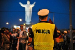 na pierwszym planie policjant, w tle pielgrzymi i świebodziński pomnik Jezusa