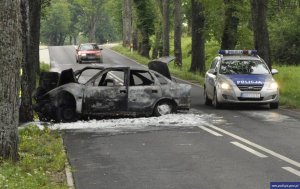 spalone auto i radiowóz zabezpieczający drogę