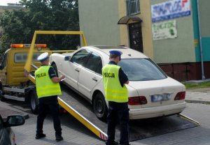 policjanci odholowują auto