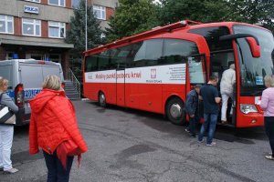 ludzie wchodzący do autokaru