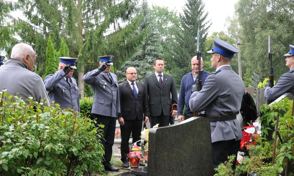 policjanci oddają honory nad grobem kolegi