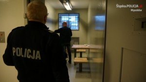 zatrzymany doprowadzony przez policjanta do policyjnej celi
