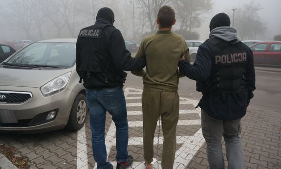 policjanci prowadzą zatrzymanego