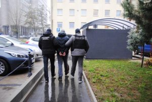 policjanci konwojują zatrzymanego