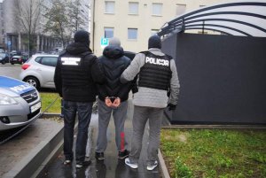 policjanci konwojują zatrzymanego