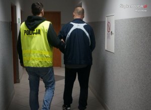 policjant prowadzi zatrzymanego