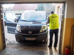 zabezpieczony samochód i policjant wykonujący czynności